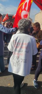 travailleuse de l'hôpital portant une blouse avec marqué "soignant malmené, patient mal soigné"